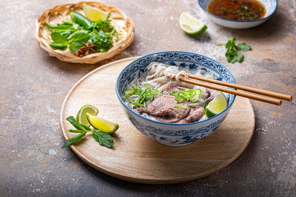 Pho bo with beef tonque, herbs, spicy sauce and lime